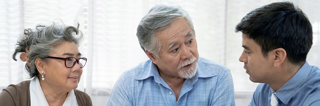 Elderly couple meeting with insurance agent to discuss assets.