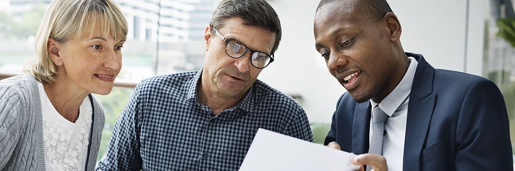 A couple meets with their financial advisor to discuss the pros and cons of an IRA vs. 401(k).