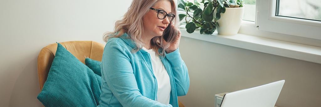 A woman speaks with a financial advisor on the phone after the unexpected loss of a loved one.