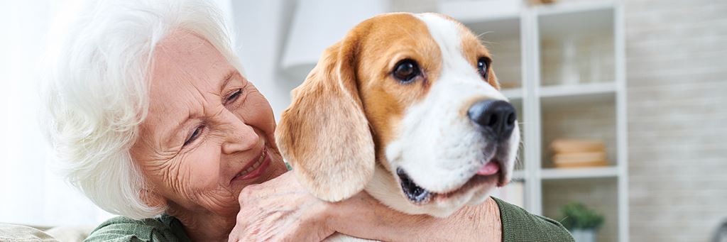 A senior holding a dog.