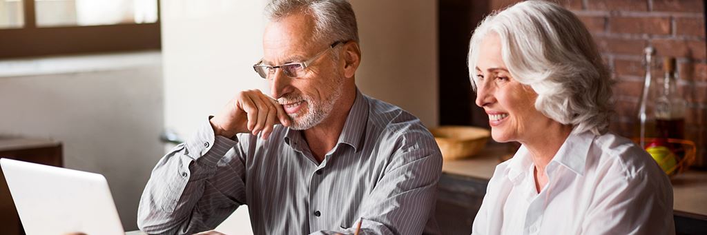 An older couple at a laptop searches for the best type of life insurance.