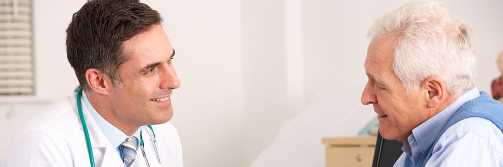 A senior man meets with his doctor.