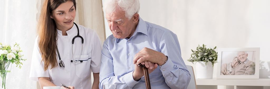 A senior reviews a health care proxy document with a medical professional.