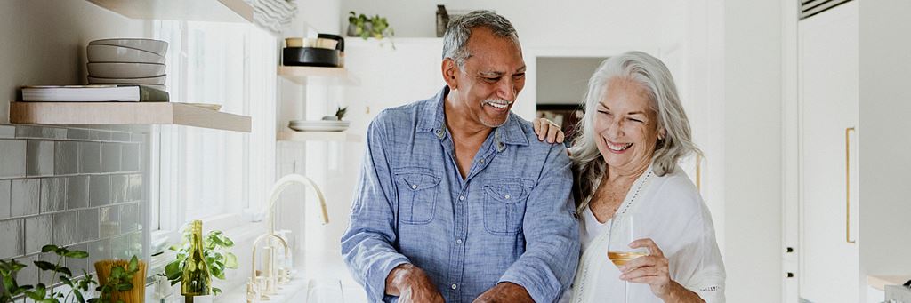 An older couple relaxing in the kitchen.