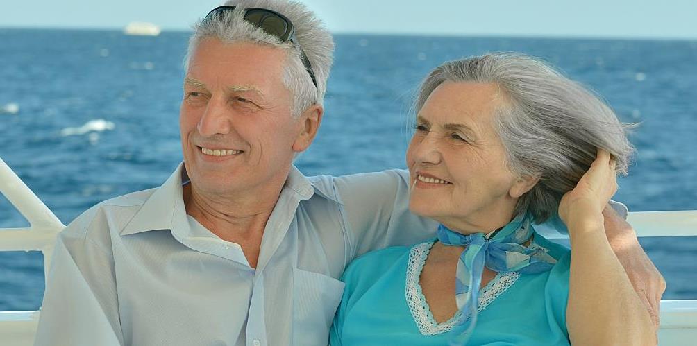 A couple relaxes on a boat after having found a strategy to reduce their IRMAA bill.
