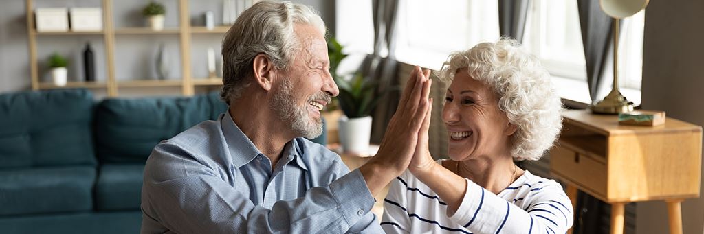 A retired couple high-fives.