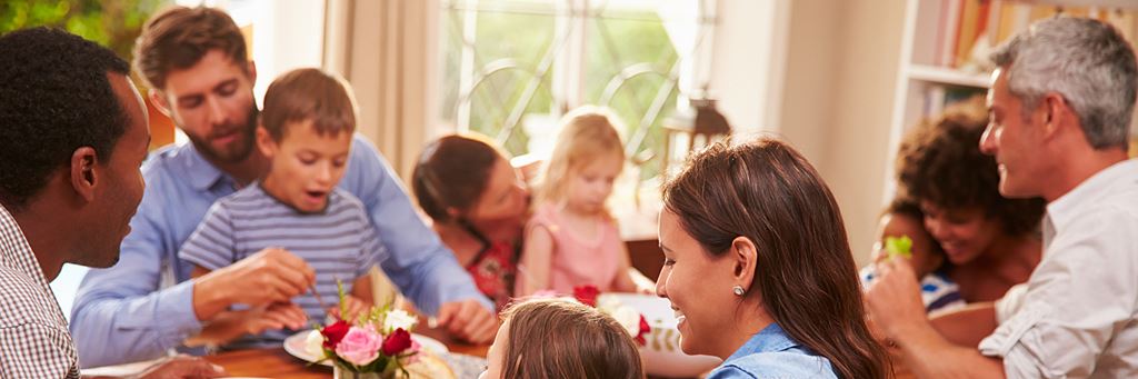 A diverse family eats a meal together