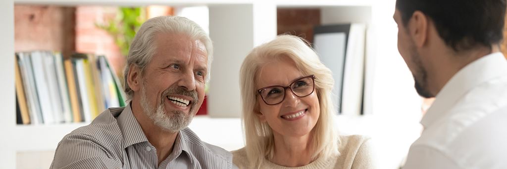 An elderly couple discusses Medigap plans with an insurer.