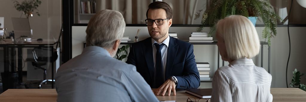 A lawyer speaking with a senior couple about how to prevent inheritance theft.