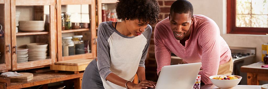 A couple uses a laptop to check on their retirement savings.
