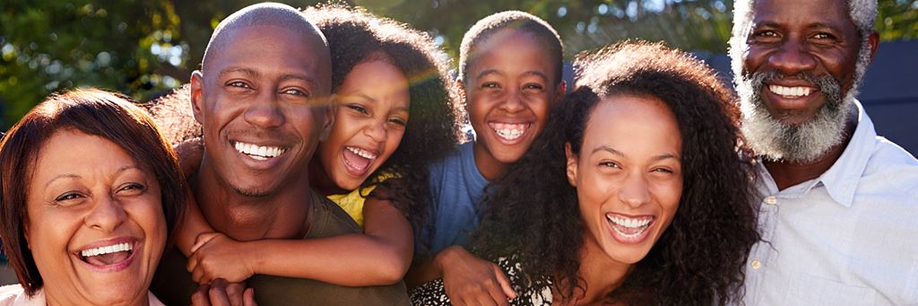 A multigenerational family laughs and smiles together.
