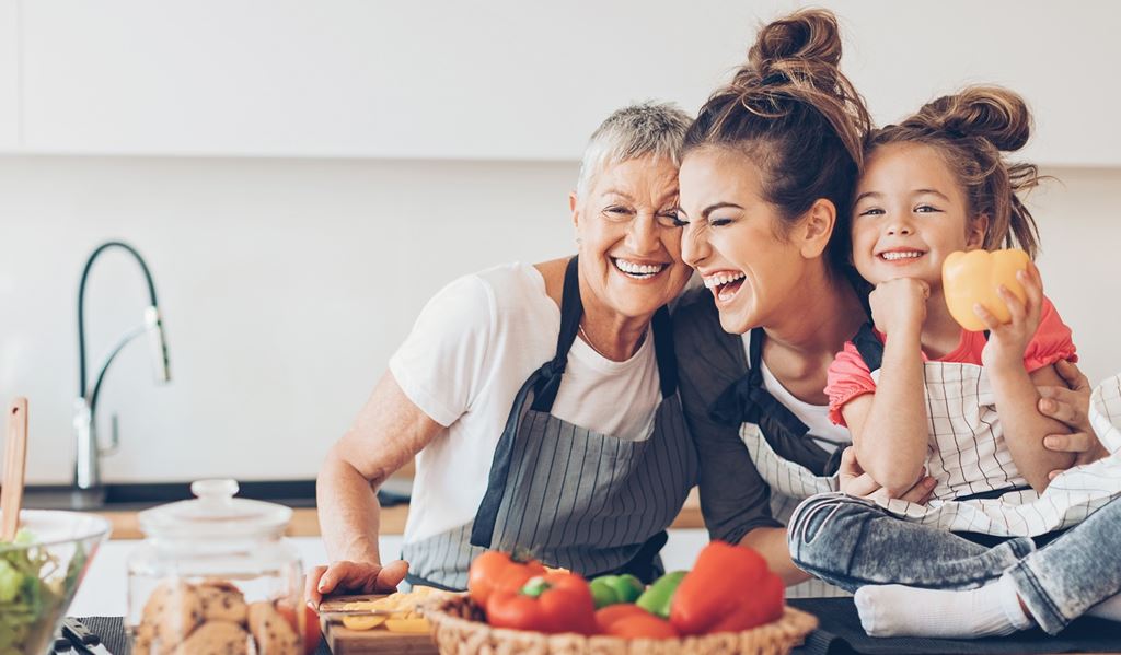 Three generations of women having fun in the kitchen.