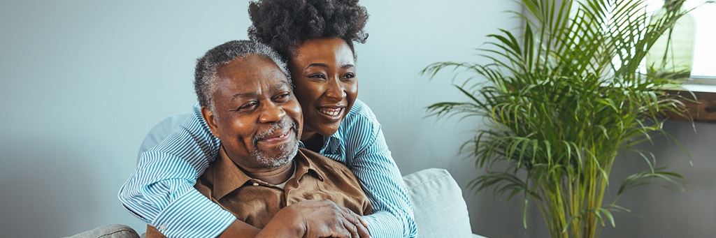 A young woman hugs her senior father.
