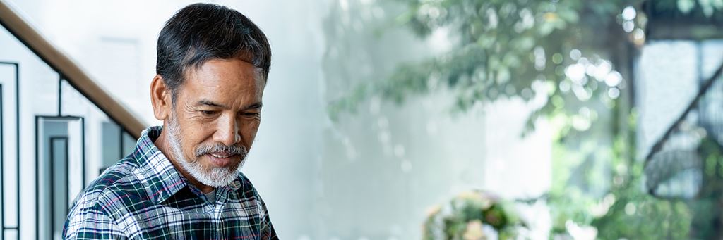 A senior man explores asset protection plans on his computer.
