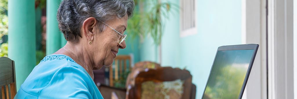 An older woman uses a laptop.