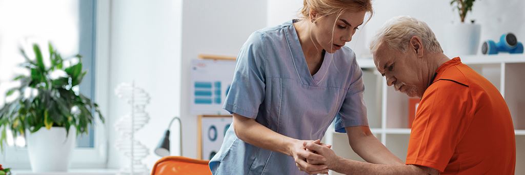 A skilled nurse helps a senior patient who is recovering from an injury.
