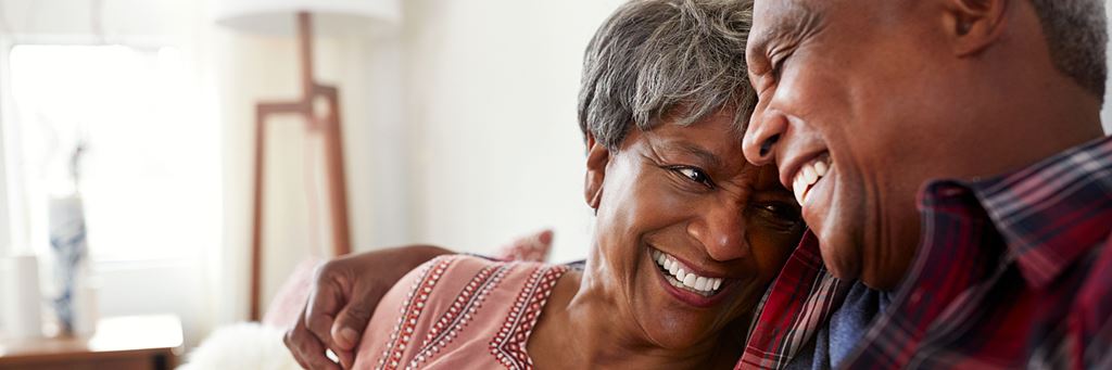 An older couple smiles.