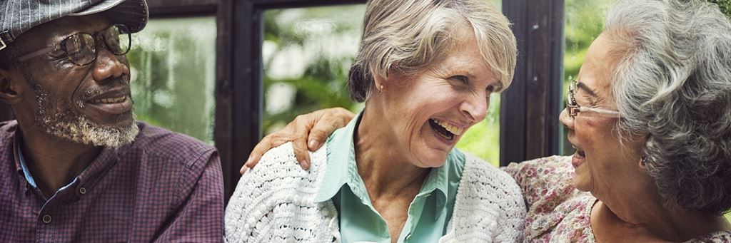 Three laughing seniors enjoy some free time in retirement.