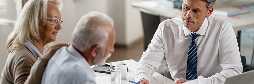 An attorney discusses a living will with a senior couple.