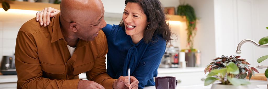 A senior couple packs up boxes in their kitchen before relocating in retirement.