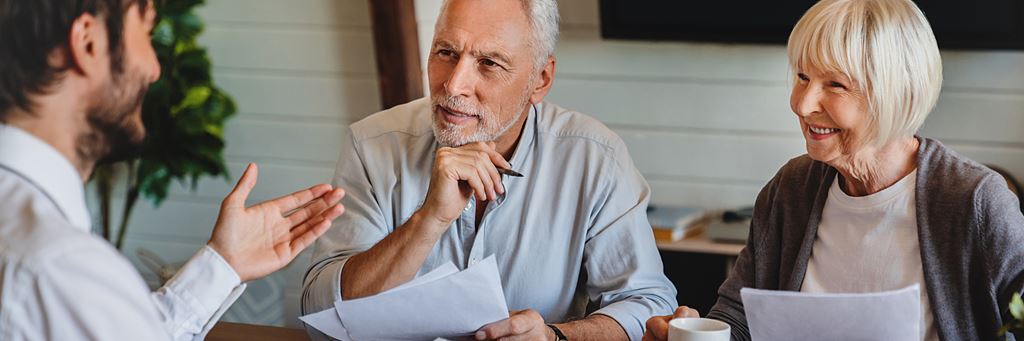A senior couple discusses sustainable investing with a financial advisor.