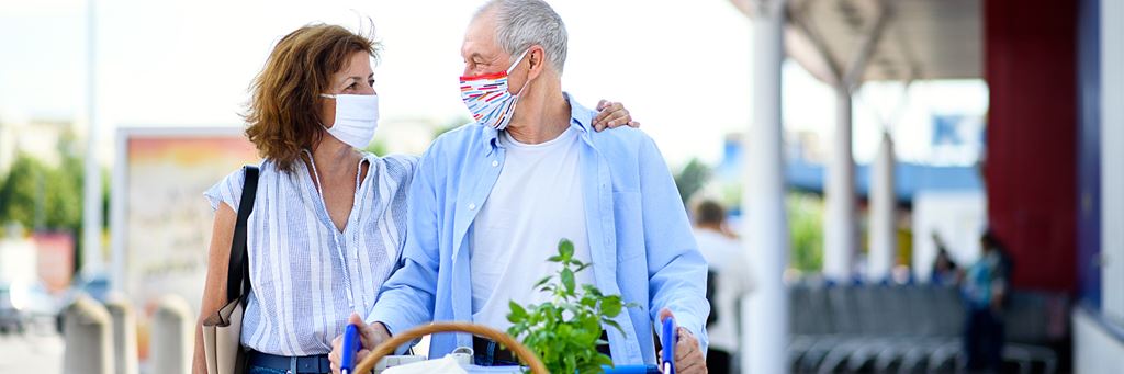 A retired couple wearing face masks while shopping for groceries.
