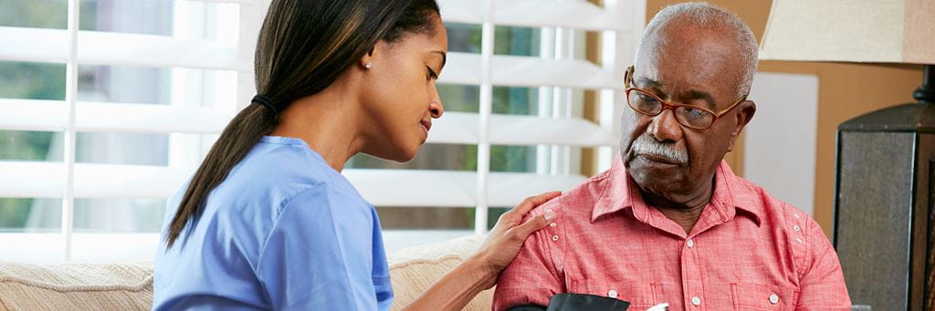 A nurse takes the blood pressure of a senior man.