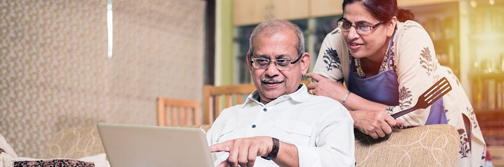 A senior couple researches Medicare Supplement insurance plans on a laptop.
