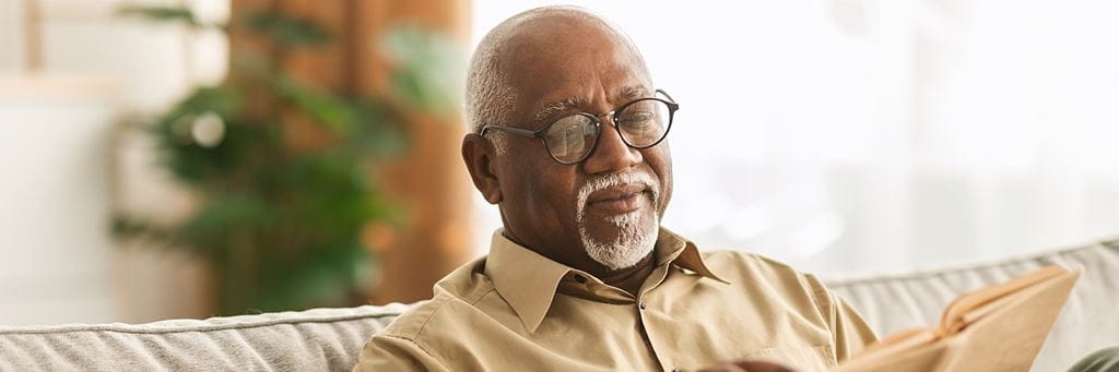 A senior man reads a book.