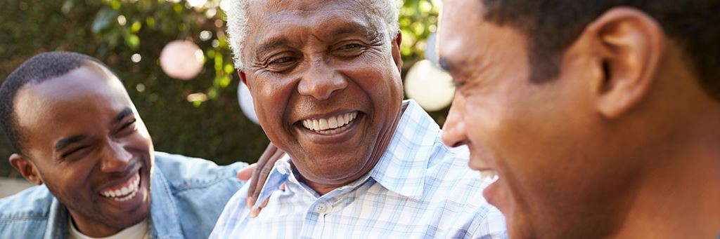 A senior man talking to his adult sons.