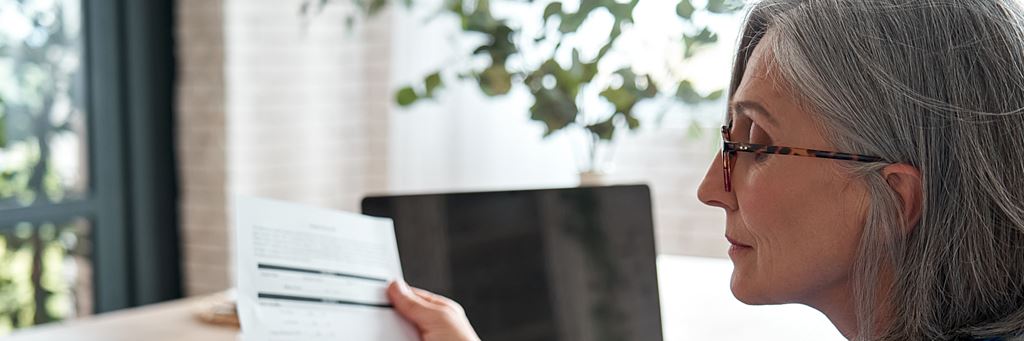A senior woman looks at her investment statement.