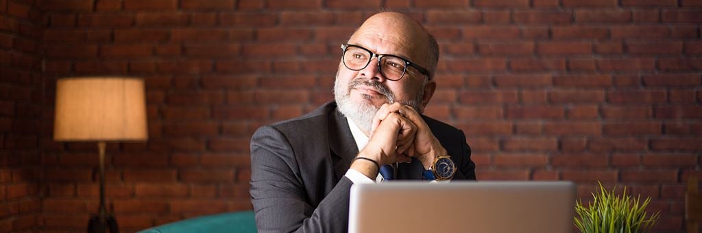 A man thinks while resting his chin on his fists.