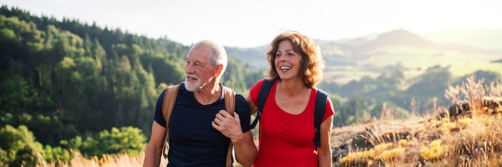 A retired couple enjoys senior independence on a hike in the mountains.