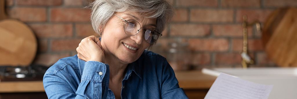 A senior woman reviews open enrollment paperwork.