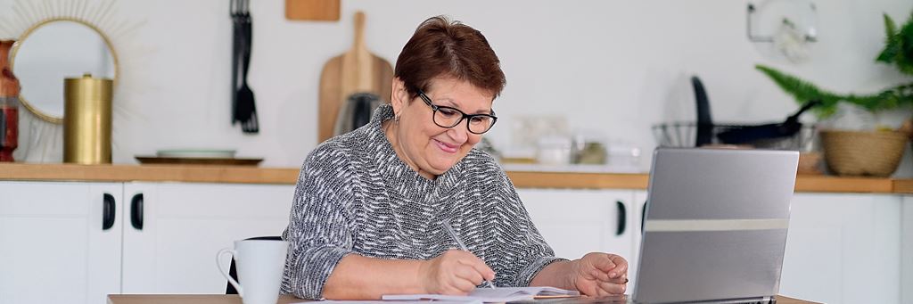 A senior woman uses her laptop for retirement planning.