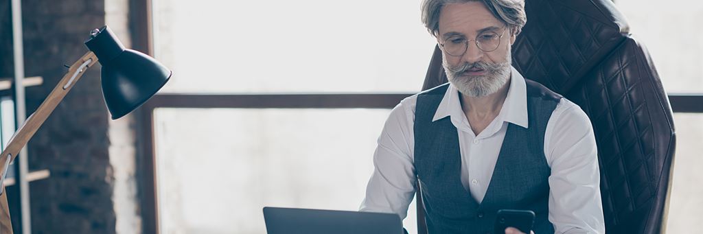 A senior businessman checks his investment portfolio and cryptocurrency accounts on his phone.