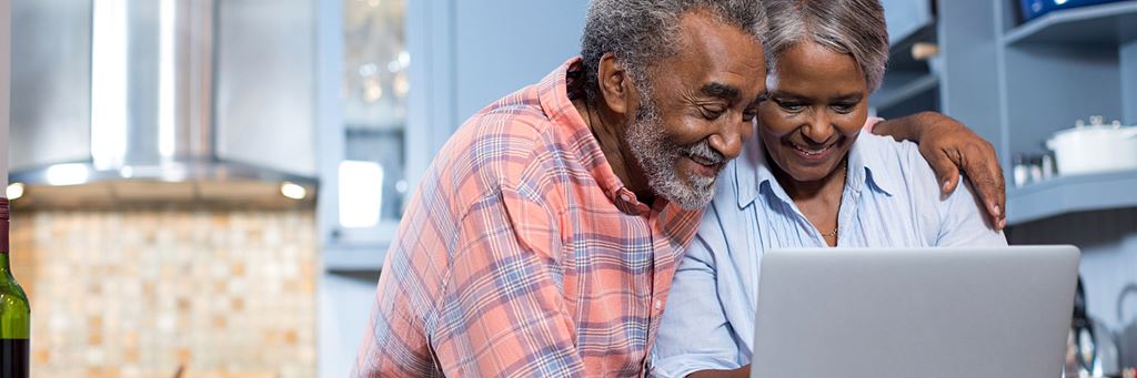 An older couple looks at a laptop computer while planning for retirement.