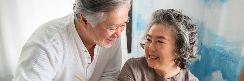 An older couple looks at each other and smiles.