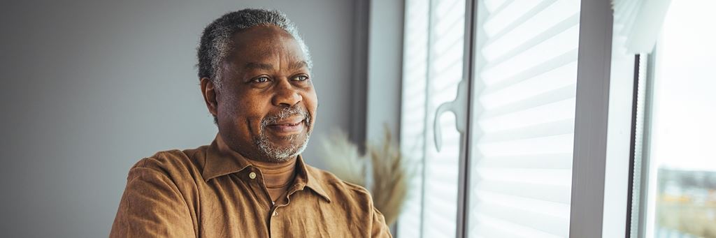 An older man smiles.