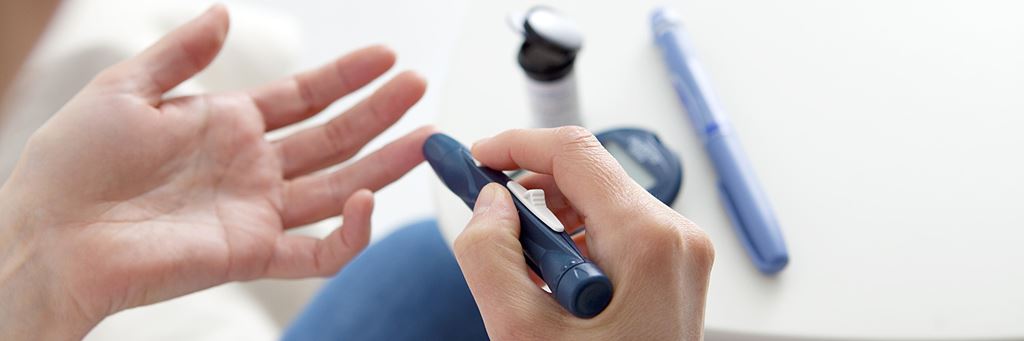 A woman pricks her finger to test her blood sugar levels.