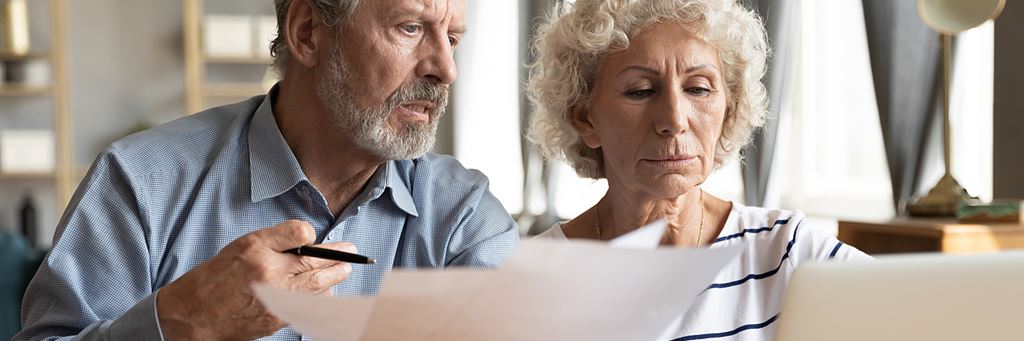 A couple reads papers that explain a Medicare Advantage plan.