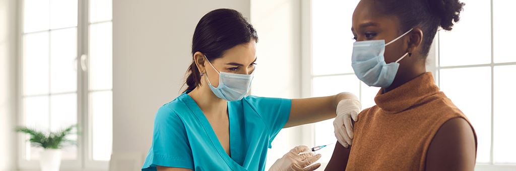 A young doctor preparing a patient's arm for a flu shot.