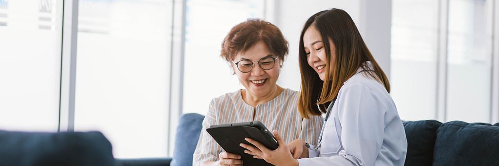 A medical professional with a tablet assists a patient during Medicare open enrollment.